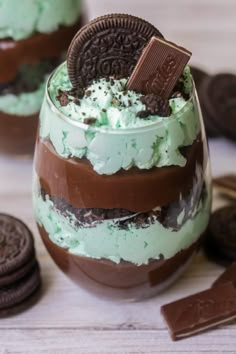 an oreo cookie dessert in a glass with mint green frosting and chocolate chips