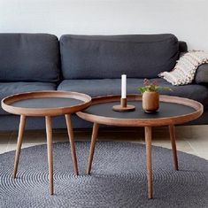 two tables sitting on top of a rug in front of a couch