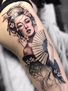 a woman with a fan tattoo on her thigh is shown in black and grey colors