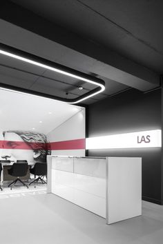 an office with black and white furniture and red accents