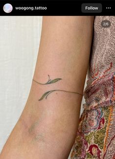 a woman's arm with a small tattoo on it