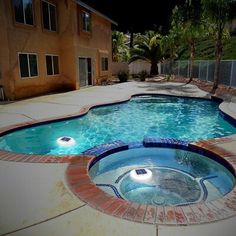 an empty swimming pool in front of a house