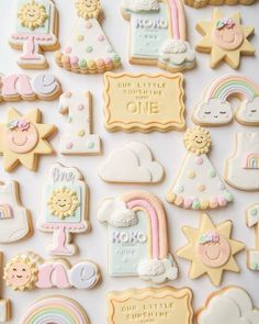 some cookies that are on top of a white table with rainbows, clouds and stars