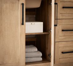 an open cabinet with towels and other items in the drawer area next to each other