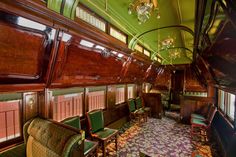 the interior of a train car with green walls and wood trimmings, decorated in floral carpeting