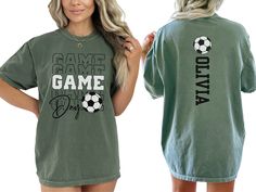 a woman wearing a green shirt that says game over with soccer balls on the back