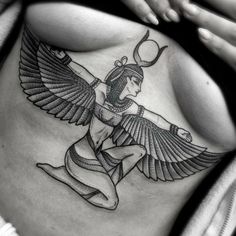 a woman's stomach with an egyptian tattoo design on her belly and the wings spread out