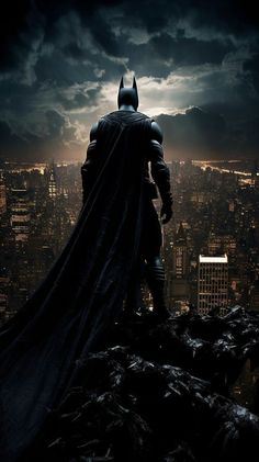 the dark knight stands on top of a hill in front of cityscape at night