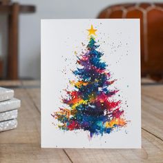 a card with a colorful christmas tree on it sitting on a table next to stacks of coasters