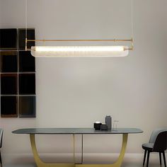 a modern dining room table with two chairs and a large rectangular light fixture hanging over it