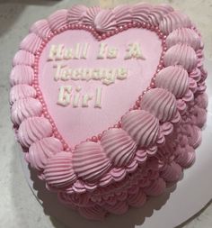 a heart - shaped cake with pink frosting that says hell is a teenage girl