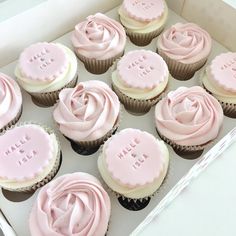 twelve cupcakes with pink frosting in a box