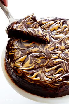 a chocolate cake with swirly frosting on top and a spoon in the middle