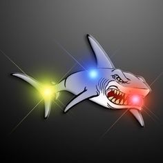 a shark with its mouth open and lights on it's side, in the dark