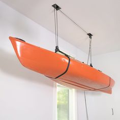 an orange kayak hanging from the ceiling