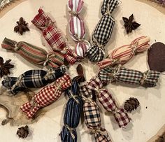 an assortment of decorative items are arranged in a circle on a wooden board with pine cones and twine