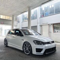 a white car parked in front of a building