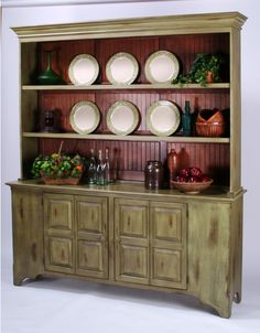 a wooden hutch with plates and bowls on it