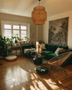 a living room filled with lots of furniture and plants on top of a hard wood floor