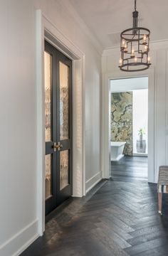 an entry way leading to a bathroom with a chandelier hanging from the ceiling