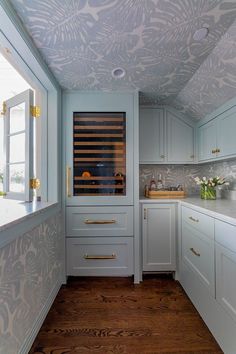 a kitchen with white cabinets and wood floors