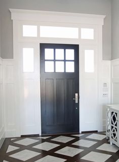 a black and white door in a room with tile on the floor next to it