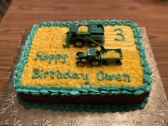 a birthday cake with two tractors on it and the words happy birthday queen written in frosting