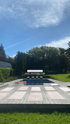 an empty swimming pool in the middle of a grassy area with a sign that says early morning yoga