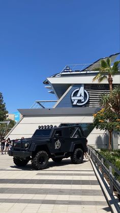 two black jeeps parked in front of a building with the avengers 4 logo on it