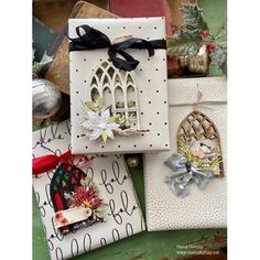 several christmas cards are stacked on top of each other with ribbons and ornaments around them