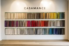 the wall is filled with different colors of fabric and has a sign that reads casmance on it