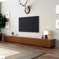 a large flat screen tv mounted to the side of a wooden cabinet in a living room