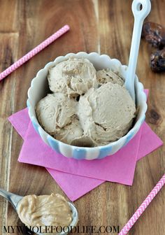 a bowl filled with ice cream sitting on top of a table next to two spoons