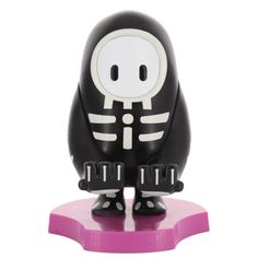 a black and white figurine sitting on top of a pink base