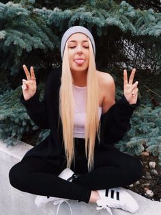 a woman with long blonde hair sitting on the ground