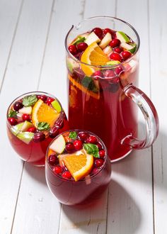 two glasses filled with red liquid and fruit