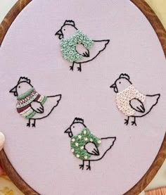 three birds are sitting on the edge of a embroidery hoop