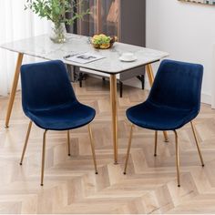 two blue chairs sitting at a white table