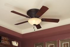 a ceiling fan in a room with red walls