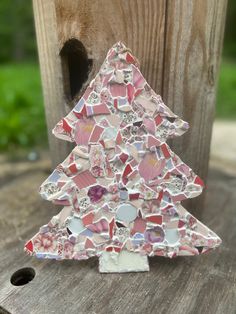 a small mosaic christmas tree sitting on top of a wooden table