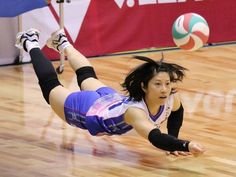 a female volleyball player dives for the ball