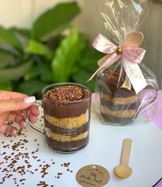 a person is holding a spoon over a mug with chocolate cake in it and sprinkles on the table