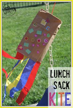 the lunch sack kite is hanging from a chain in the grass with words underneath it