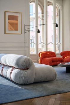 a living room filled with lots of furniture and decor on top of a blue rug