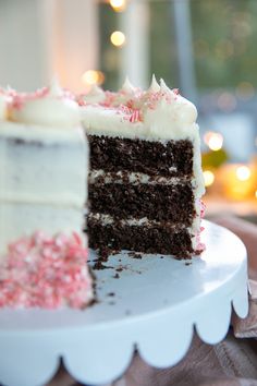 a slice of cake with white frosting and pink sprinkles