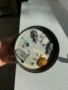 a person holding a black and white plate with halloween decorations on it's surface