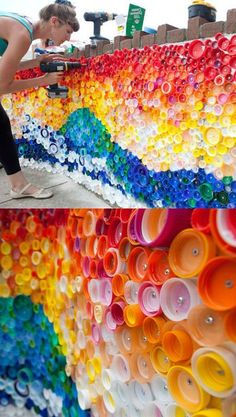 a woman standing next to a wall made out of plastic cups