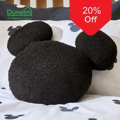 a black mickey mouse stuffed animal laying on top of a bed with 20 % off