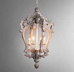 an old - fashioned light fixture with three lights hanging from it's center and two small candles in the middle