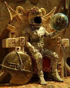 a man in an astronaut suit sitting on a chair with a globe and other items around him